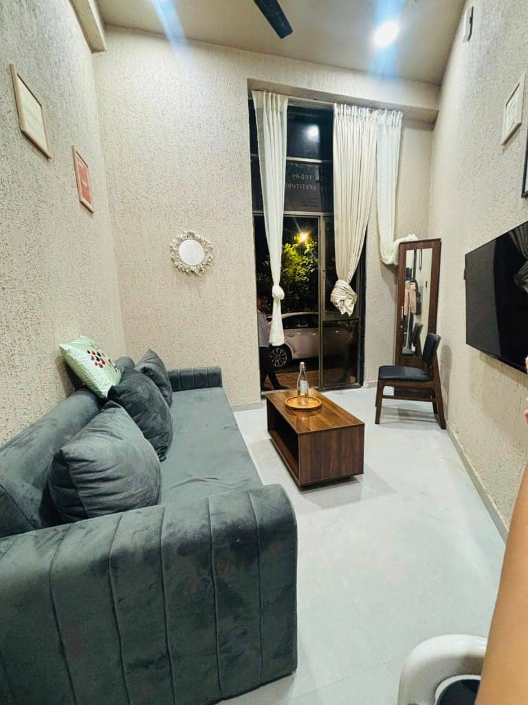 Yuzu studio with a grey sofa lounge, coffee table and full-length mirror